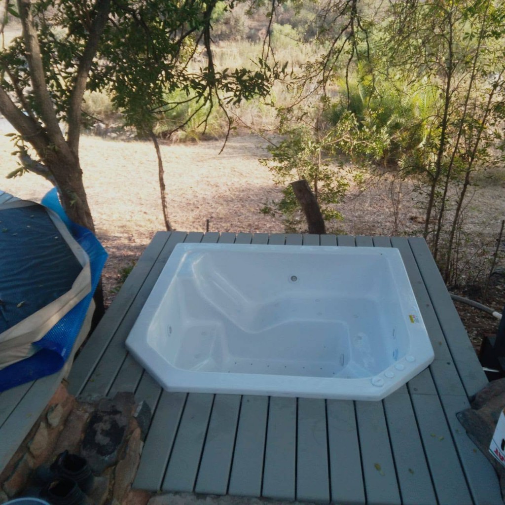 Grey timber deck built around an outdoor jacuzzi