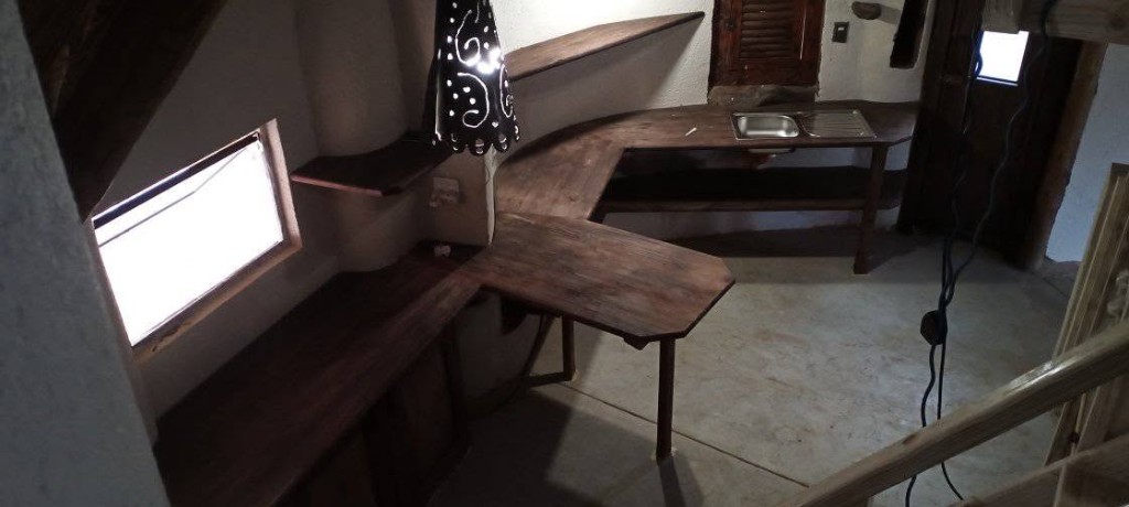 Custom dark wood kitchen counters and shelves fitted to curved walls