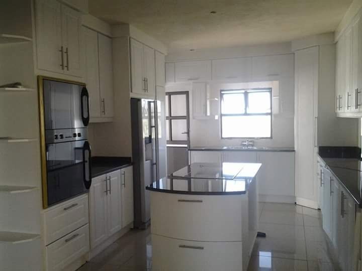 Fitted white kitchen with island, ovens and fridge