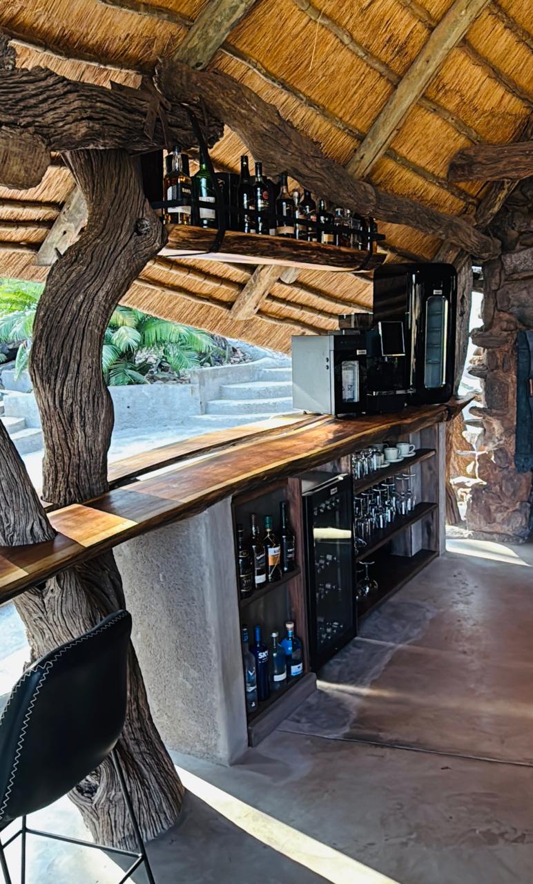 Live-edge bar wrapped around a tree branch under thatch