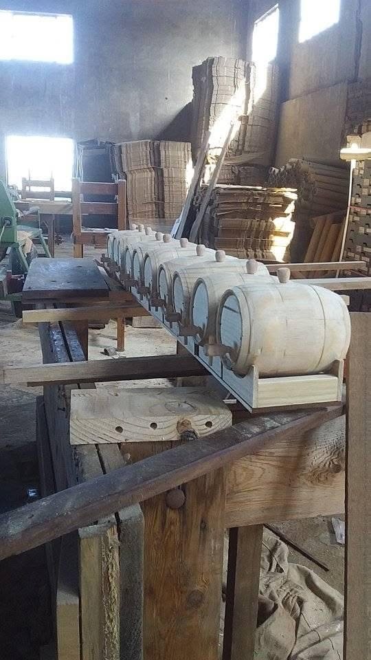Row of small turned wooden barrels on a workshop stand