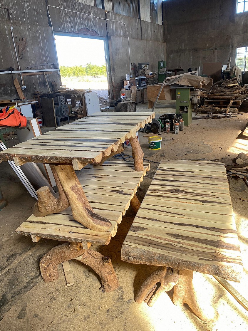 Rustic wooden benches and tables in Mo's workshop