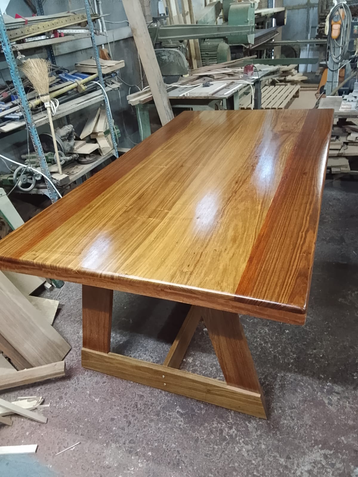 Gloss finished X-base dining table in the workshop
